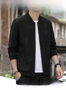 Close-up detail of a men's black jacket with red leaf patterns and stand collar design