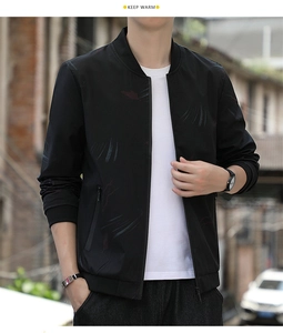 Close-up of black bomber jacket featuring blue and red print with ribbed cuffs and stand collar