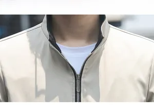 Detailed view of men's beige stand collar jacket featuring high quality metal zipper