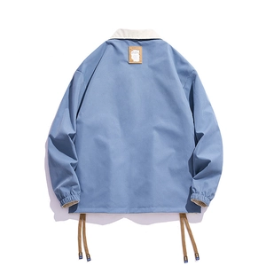 Back view of blue casual reversible coach jacket with contrast collar and drawstring hem
