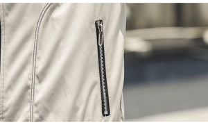 Detailed macro view of the silver metal zipper and double stitching on a cream men's jacket