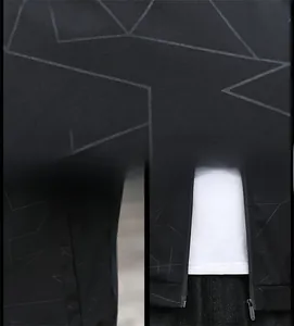 Detail view of black jacket showing geometric print, zipper, and side pockets texture