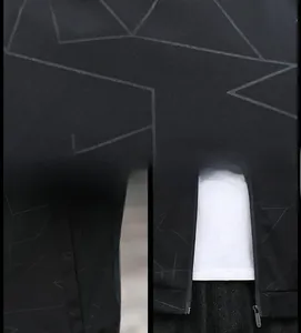 Detail der schwarzen Bomberjacke mit grauen geometrischen Mustern und Qualitätsreißverschluss