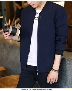 Detail view of navy blue bomber jacket with black ribbed collar and zipper closure