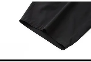 Detailed close-up of wide-leg hem on black quick-dry breathable men's sports shorts