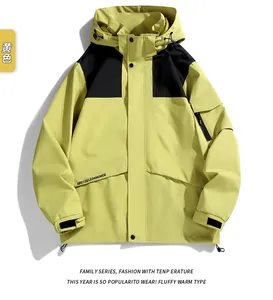 Detail of yellow waterproof outdoor jacket featuring contrast black zippers and hood