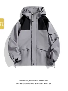 Detail of dark grey waterproof hooded jacket with functional pockets and velcro cuffs