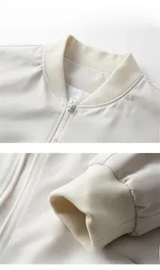 Detailed view of beige bomber jacket featuring ribbed collar, cuffs and metallic zipper