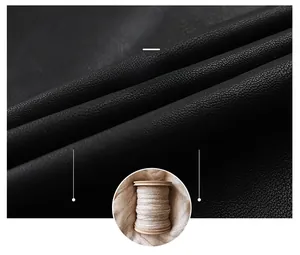 Detail of black pebbled leather jacket fabric and a white wool spool for warmth
