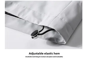 Detail of adjustable elastic drawstring hem with toggle on light gray outdoor jacket