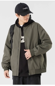 Détail d'une veste de baseball vert olive avec poignets côtelés et zip frontal