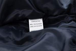 Macro view of the internal fabric composition and care label on this men's casual jacket