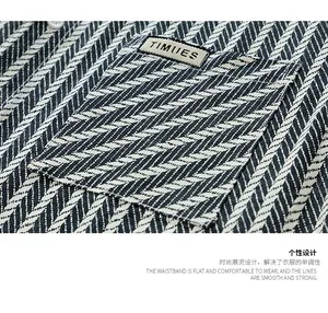 Macro view of navy herringbone cotton fabric with square pocket and brand woven label
