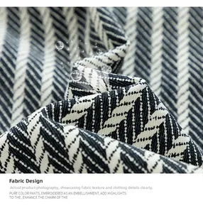 Close-up of black and white herringbone cotton fabric texture with water droplets