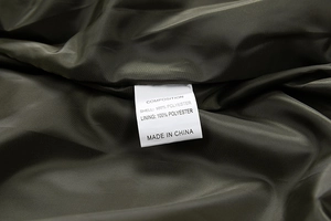 Detail view of the inner wash label showing 100% polyester fabric composition of the jacket