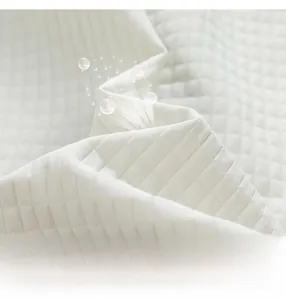 Detailed close-up of premium white quilted fabric texture with waffle-knit patterns