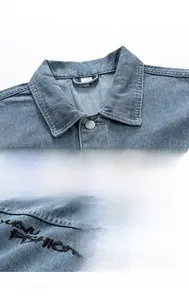 Detail of vintage blue denim vest with metal buttons and black letter embroidery