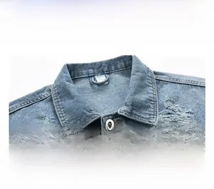 Close-up of light blue denim jacket with metal buttons and distressed ripped details
