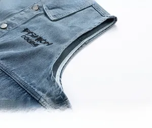 Detail of vintage denim vest with Fashion Cool embroidery and metal button closure