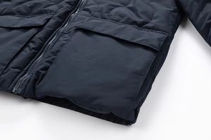 Detail of navy blue quilted jacket with gourd pattern stitching and metal zipper