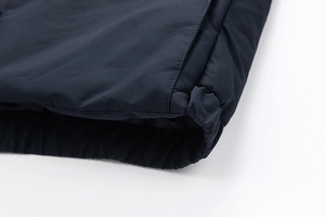 Detail of windproof elastic hem and precise stitching on dark blue men's cotton jacket