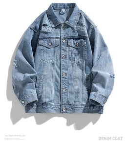 Detail of light blue washed denim jacket featuring distressed ripped edges and metal buttons