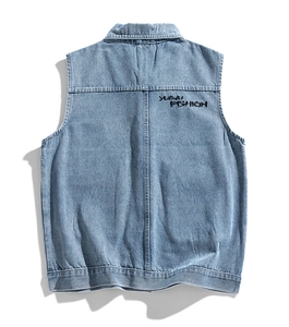 Detail view of denim vest back showing the YUAVU FASHION black embroidery on washed blue fabric