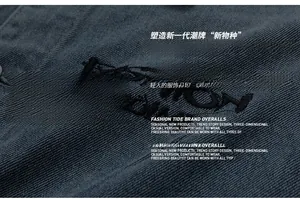 Detailed macro view of dark blue denim fabric with black FASHION letter embroidery