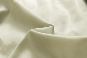 Macro shot of high-quality beige woven fabric with elegant silk luster and fine texture