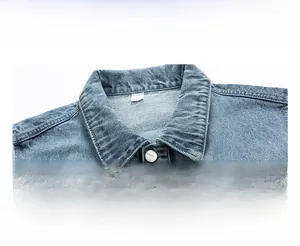 Detailed close-up of light blue denim vest collar featuring metal buttons and size label