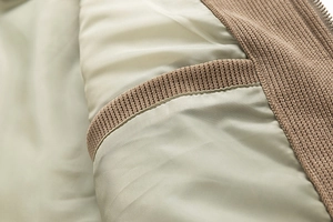 Detailed close-up of mens jacket inner lining with ribbed pocket and metal zipper