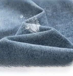 Macro shot of blue washed denim fabric with water-resistant coating and woven twill detail