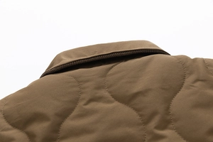 Close-up of brown quilted jacket collar with wave pattern and ribbed lining detail