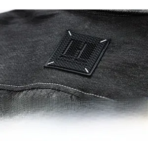 Détail macro de chemise en jean de qualité avec écusson et surpiqûres blanches contrastées