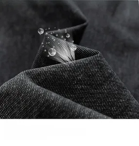 Détail macro du tissu denim foncé avec texture sergée et revêtement de surface déperlant