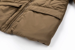 Detail of dark brown quilted cotton jacket with metal zipper and large flap pockets