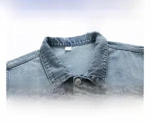 Detailed close-up of light blue washed denim vest neckline with metal button and XL tag