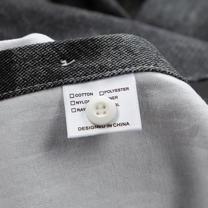 Gros plan sur la texture du coton avec étiquette de lavage et bouton blanc de chemise