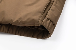 Detail shot of men's dark brown jacket showing windproof fabric and elastic cuffs