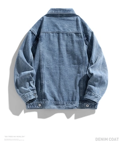 Detail view of the blue denim jacket back featuring dropped shoulders and metal button tabs