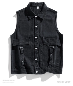 Detail of black denim vest showing metallic ring strap and industrial workwear pockets