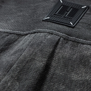Vue détaillée du tissu denim avec surpiqûres blanches et écusson logo H rectangulaire