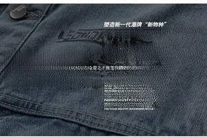 Macro detail of blue-grey denim fabric featuring double stitching and matte metal button