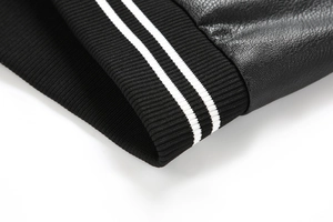 Detailed close-up of ribbed cuffs with white stripes on a black PU leather jacket