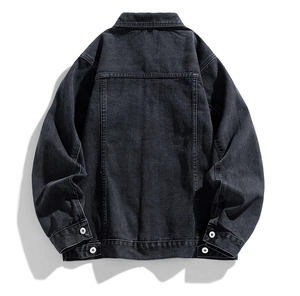 Rear view of washed black denim jacket showing heavy cotton texture and adjustment buckles