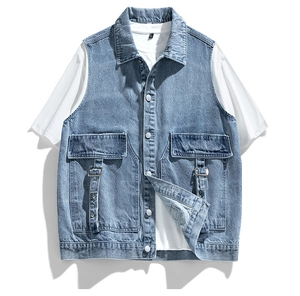 Detailed close-up of blue washed denim vest with utility pockets and metal buckles