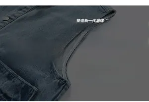 Detail view of denim vest showing armhole edging, large pocket and matte metal button