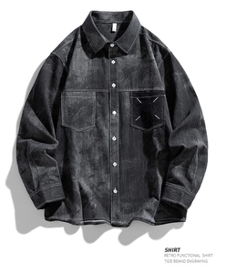 Détail d'une chemise en jean délavé avec poches poitrine et surpiqûres signature au tissu