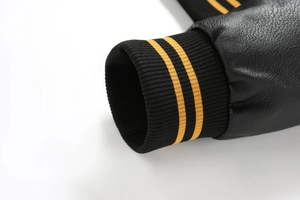 Detail of black PU leather sleeve with yellow striped elastic ribbed cuff on biker jacket