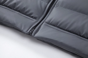 Detailed macro view of the durable plastic zipper and high-quality quilting on men's cotton jacket